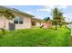 Backyard with lawn, wooden playset, and covered patio area at 2973 Breezy Meadows, Clearwater, FL 33760