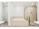 Bright bathroom featuring soaking tub, glass shower, and tiled walls at 2973 Breezy Meadows, Clearwater, FL 33760