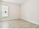 An empty bedroom with wood-look tile flooring and a window with blinds at 2973 Breezy Meadows, Clearwater, FL 33760