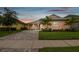 Charming peach colored exterior with tidy lawn, paver driveway, and palm trees at 2973 Breezy Meadows, Clearwater, FL 33760