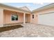 Exterior view of a peach house with white trim, two-car garage, and palm trees at 2973 Breezy Meadows, Clearwater, FL 33760