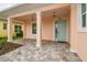 Covered front porch with brick pavers and light-blue trim with view to neighboring yard at 2973 Breezy Meadows, Clearwater, FL 33760