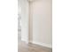 Image displaying the hallway with views into a room with white walls and wood-look tile floors at 2973 Breezy Meadows, Clearwater, FL 33760