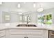 Bright, modern kitchen island with stainless steel sink, and view of the outdoor play area at 2973 Breezy Meadows, Clearwater, FL 33760
