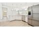Well-lit kitchen with white cabinets, stainless appliances, and open layout to living areas at 2973 Breezy Meadows, Clearwater, FL 33760