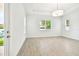 Bright living room features wood-look tile floors, white walls, and three large windows at 2973 Breezy Meadows, Clearwater, FL 33760