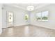 Bright living room featuring wood-look tile floors, white walls, and access to back patio at 2973 Breezy Meadows, Clearwater, FL 33760