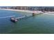 Aerial view of a pier extending into the ocean, with boats and a beach visible in the distance at 2973 Breezy Meadows, Clearwater, FL 33760