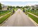 A street view of a community entrance featuring well-manicured landscaping and security gate at 2973 Breezy Meadows, Clearwater, FL 33760