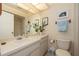 Well-lit bathroom with a vanity, mirror, and decorative plants at 307 Los Prados Dr # 307, Safety Harbor, FL 34695