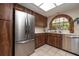 This updated kitchen features stainless steel appliances, wood cabinets, and a window with a view at 307 Los Prados Dr # 307, Safety Harbor, FL 34695