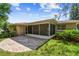 View of home's screened in patio overlooking the green backyard at 3249 Parkway Pl, Palm Harbor, FL 34684