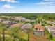 Expansive aerial view of a residential community featuring lush landscaping, a serene lake, and a mix of tile roof homes at 3326 Barbour Trl, Odessa, FL 33556