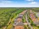 An aerial view showcases a neighborhood surrounded by lush greenery, manicured lawns, and community roads at 3326 Barbour Trl, Odessa, FL 33556