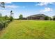 Large backyard with a lush green lawn and fenced perimeter with a large screened patio with a pool and hot tub at 3326 Barbour Trl, Odessa, FL 33556