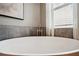 Close-up of a modern soaking tub near a window with natural light and stylish tile surround at 3326 Barbour Trl, Odessa, FL 33556