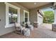 Inviting covered front porch with comfortable seating and brick flooring near the garage at 3326 Barbour Trl, Odessa, FL 33556