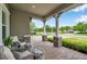 Inviting front porch featuring stone-clad columns, comfortable seating, and a brick-paved floor at 3326 Barbour Trl, Odessa, FL 33556