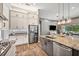 Modern kitchen with stainless steel appliances, granite countertops, and gray tile backsplash at 3326 Barbour Trl, Odessa, FL 33556