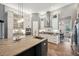 Open kitchen featuring an island with sink, granite countertops, pendant lights and ample storage at 3326 Barbour Trl, Odessa, FL 33556