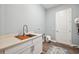 Laundry room featuring a sink, storage cabinets, counter space, and stylish decor at 3326 Barbour Trl, Odessa, FL 33556