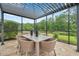 Covered outdoor dining area with table and chairs, perfect for enjoying meals while overlooking the backyard at 3326 Barbour Trl, Odessa, FL 33556