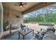 Covered outdoor patio with travertine tile, ceiling fan, outdoor furniture, and views of the pool at 3326 Barbour Trl, Odessa, FL 33556