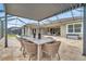 Covered patio features a dining table, spa, and seamless access to indoor and outdoor living spaces at 3326 Barbour Trl, Odessa, FL 33556