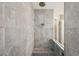 Walk-in shower with stone-look tile, a built-in niche, and glass panel at 3326 Barbour Trl, Odessa, FL 33556