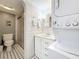 Bathroom featuring a shower, toilet, stackable washer/dryer and vanity with traditional white tile at 3620 41St S Way # B, St Petersburg, FL 33711