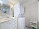 Bathroom with a stackable washer/dryer and vanity with traditional white tile at 3620 41St S Way # B, St Petersburg, FL 33711