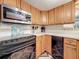 Kitchen featuring black appliances, wooden cabinets, tile backsplash, and bright counterspace at 3620 41St S Way # B, St Petersburg, FL 33711