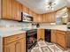 Well-equipped kitchen featuring updated appliances, wooden cabinets, and patterned tile floor at 3620 41St S Way # B, St Petersburg, FL 33711