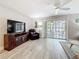 Cozy living room with a ceiling fan, large windows, and sliding glass doors leading to an outdoor space at 3620 41St S Way # B, St Petersburg, FL 33711