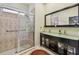 Bathroom featuring a walk-in shower, double sink vanity, and an elegant mirror, creating a spa-like atmosphere at 3762 Darston St, Palm Harbor, FL 34685