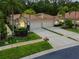 Inviting home featuring a tile roof, lush landscaping, and a multi-car garage, creating great curb appeal at 3762 Darston St, Palm Harbor, FL 34685
