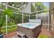 Screened lanai featuring a hot tub and tropical plants at 3762 Darston St, Palm Harbor, FL 34685