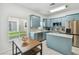 Bright kitchen with blue cabinets, stainless steel appliances, tile floors and eat-in table, creating a modern space at 3762 Darston St, Palm Harbor, FL 34685