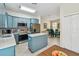 Modern kitchen features blue cabinets, stainless steel appliances, tile floors, and an island, creating a functional layout at 3762 Darston St, Palm Harbor, FL 34685