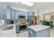 Stylish kitchen featuring blue cabinets, a stainless refrigerator, and a tile backsplash, creating a great modern look at 3762 Darston St, Palm Harbor, FL 34685