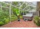 Enclosed patio with brick flooring, hot tub, and view of the lush landscaping at 3762 Darston St, Palm Harbor, FL 34685