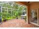 Enclosed patio with brick flooring, a hot tub, and views of lush landscaping at 3762 Darston St, Palm Harbor, FL 34685