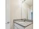 A simple bathroom featuring a granite countertop, neutral walls, and mirror at 3860 Obsidian Dr, Spring Hill, FL 34609