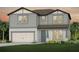 Charming two-story home featuring gray siding, a two-car garage, and beautifully landscaped front yard at 3860 Obsidian Dr, Spring Hill, FL 34609