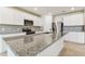 A well-equipped kitchen features a granite island, stainless steel appliances, and ample cabinet space at 3860 Obsidian Dr, Spring Hill, FL 34609