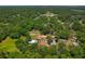 Expansive aerial view of the property encircled in red, surrounded by lush greenery and mature trees at 39542 Friends Ave, Zephyrhills, FL 33540