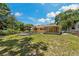 Grassy backyard view featuring a cozy deck and a charming covered patio, perfect for outdoor entertaining at 39542 Friends Ave, Zephyrhills, FL 33540