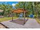 Backyard with a gazebo, a table with chairs, and two storage sheds, perfect for relaxation and outdoor gatherings at 39542 Friends Ave, Zephyrhills, FL 33540
