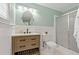 Bathroom features a wood vanity, modern fixtures, and a shower with sliding glass doors at 39542 Friends Ave, Zephyrhills, FL 33540