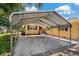 Carport attached to a quaint yellow home with dark shutters, offering convenient covered parking at 39542 Friends Ave, Zephyrhills, FL 33540